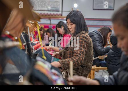 220322 -- CHONGQING, le 22 mars 2022 -- des femmes fabriquent des produits en Xilankapu, qui est une sorte de brocart Tujia, dans un studio de la ville de Xiaonanhai, dans le district de Qianjiang, dans le sud-ouest de la Chine, Chongqing, le 22 mars 2022. Xilankapu, également connu sous le nom de tricot Floral Bedsweetings, a été inscrit au patrimoine culturel immatériel national en 2006. CHINE-CHONGQING-TUJIA BROCADE CN HuangxWei PUBLICATIONxNOTxINxCHN Banque D'Images