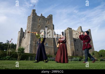 Musiciens avec leurs instruments du 15e siècle laissés à serrer Lizzie Gutteridge jouant un Shawm alto, Jackie Phillips avec une harpe, et Terry Mann jouant un buisine, dans le domaine du château de Bolton dans le North Yorkshire, avant de jouer pendant Medieval Music in the Dales, le festival de musique médiévale d'Angleterre qui a lieu du 8 au 10 septembre. Date de la photo : jeudi 7 septembre 2023. Banque D'Images