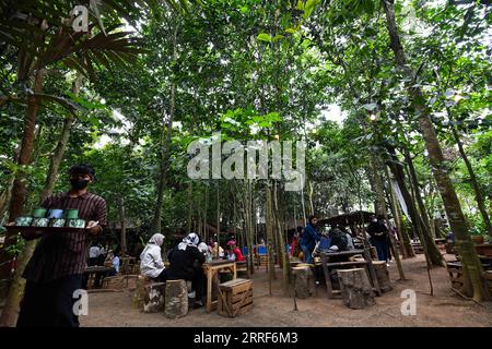 220401 -- SOUTH TANGERANG, le 1 avril 2022 -- les gens dînent dans un restaurant nommé Warung Tuman à South Tangerang, Indonésie, le 1 avril 2022. Situé dans les bois, ce restaurant est localement célèbre pour ses cuisines javanaise et de Sumatra occidental. Les populations locales et les gens des villes voisines telles que Jakarta viennent ici pour profiter de la nourriture dans l'étreinte de la nature. INDONÉSIE-SUD TANGERANG-LIFESTYLE XuxQin PUBLICATIONxNOTxINxCHN Banque D'Images