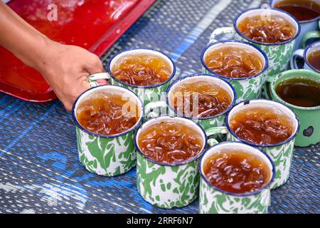 220401 -- SOUTH TANGERANG, le 1 avril 2022 -- Un personnel sert des boissons aux convives dans un restaurant nommé Warung Tuman à South Tangerang, Indonésie, le 1 avril 2022. Situé dans les bois, ce restaurant est localement célèbre pour ses cuisines javanaise et de Sumatra occidental. Les populations locales et les gens des villes voisines telles que Jakarta viennent ici pour profiter de la nourriture dans l'étreinte de la nature. INDONÉSIE-SUD TANGERANG-LIFESTYLE XuxQin PUBLICATIONxNOTxINxCHN Banque D'Images