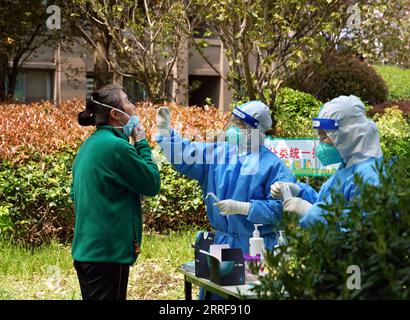 220406 -- SHANGHAI, le 6 avril 2022 -- Un travailleur médical prélève un échantillon d'un résident pour un test d'acide nucléique dans une communauté du district de Songjiang à Shanghai, dans l'est de la Chine, le 6 avril 2022. Shanghai a lancé mercredi une autre série de tests d’antigènes et d’acides nucléiques à l’échelle de la ville dans le cadre des efforts visant à contenir la récente résurgence des cas de COVID-19 dans la métropole, selon les autorités locales. La décision a été prise sur la base des résultats des tests de masse d’acides nucléiques effectués lundi, selon le groupe leader municipal de Shanghai pour la prévention et le contrôle de la COVID-19. CHINE-SHANGHAI-COVID-19-TEST CN LIU Banque D'Images