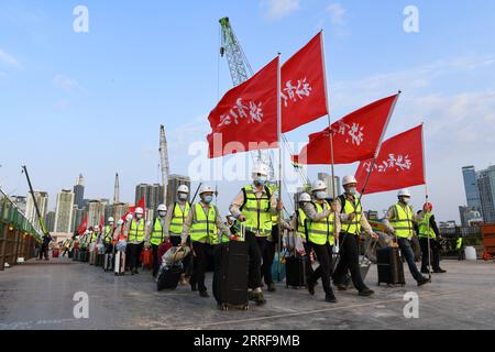 220408 -- HONG KONG, le 8 avril 2022 -- des travailleurs traversent la rivière Shenzhen par un pont temporaire pour commencer la construction d un projet d hôpital d urgence aidé par les autorités centrales chinoises à Hong Kong, dans le sud de la Chine, le 6 mars 2022. Les installations construites lors de la première étape de la construction d un projet d hôpital d urgence, aidées par les autorités centrales chinoises, ont été remises jeudi aux services compétents de la région administrative spéciale de Hong Kong. Les installations achevées comprennent 500 lits à pression négative, dont 32 unités de soins intensifs et deux salles d'opération. La construction de la première étape Banque D'Images