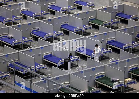 220409 -- SHANGHAI, le 9 avril 2022 -- un membre du personnel ajuste un robot sur le chantier de construction d'un hôpital temporaire au Centre national des expositions et des congrès de Shanghai dans l'est de la Chine, Shanghai, le 8 avril 2022. Shanghai a ouvert et continuera de construire davantage d'hôpitaux temporaires pour améliorer la capacité de traitement de la ville pour les infections COVID-19 dans sa dernière résurgence COVID-19, ont déclaré vendredi les autorités. Quatre hôpitaux temporaires municipaux, trois situés dans le district de Pudong et un dans le district de Chongming, ont été mis en service vendredi. Couvrant un total de 500 000 mètres carrés Banque D'Images