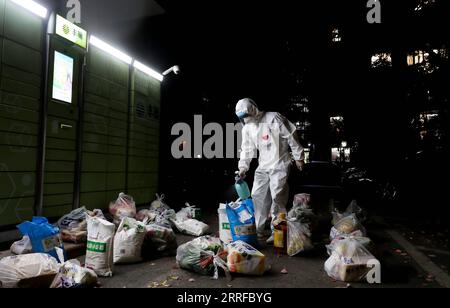 220412 -- SHANGHAI, le 12 avril 2022 -- Shi Zhongliang pulvérise des désinfectants sur les matériaux vivants nouvellement arrivés dans la soirée à Shanghai, dans l est de la Chine, le 11 avril 2022. Shi Zhongliang, un résident du canton de Qibao, district de Minhang à Shanghai, rend maintenant ses services en tant que bénévole dans sa communauté. Sa communauté résidentielle est sous gestion fermée depuis mars 18 en raison de la résurgence du COVID-19. Peu de temps après, Shi s’est joint à l’équipe de bénévoles de la communauté spontanément organisée par les résidents de la même communauté. L'équipe, avec seulement sept membres depuis le début, a grandi comme Banque D'Images