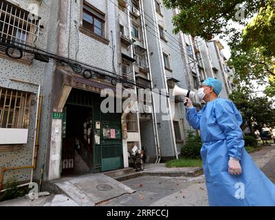 220412 -- SHANGHAI, le 12 avril 2022 -- Wei Gang diffuse des conseils aux résidents d'un quartier résidentiel du district de Baoshan à Shanghai, dans l'est de la Chine, le 12 avril 2022. Wei Gang, 78 ans, est un bénévole qui travaille en première ligne de la lutte de Shanghai contre le COVID-19. Wei Gang s'est consacré au bénévolat après sa retraite en 2004. Bien qu'il ait reçu un diagnostic de cancer en 2016 et qu'il ait vécu une période difficile de lutte contre la maladie, il a poursuivi son travail bénévole dès que son état s'est amélioré. Ces dernières années, Wei a dirigé une équipe de médiation pour aider à résoudre plus de 400 problèmes de quartier Banque D'Images