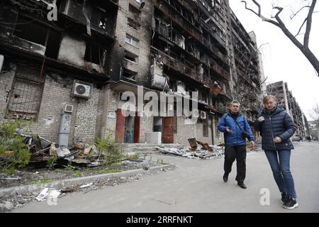 220422 -- MARIUPOL, 22 avril 2022 -- des gens passent devant un bâtiment endommagé dans la ville portuaire de Mariupol, le 21 avril 2022. Le président russe Vladimir Poutine a ordonné jeudi un blocus de l'usine Azovstal dans la ville portuaire de Marioupol au lieu de l'attaquer, ont rapporté les médias locaux. Photo de /Xinhua RUSSIA-UKRAINE-CONFLICT-MARIUPOL Victor PUBLICATIONxNOTxINxCHN Banque D'Images