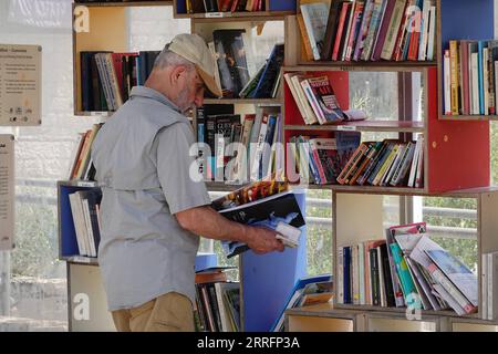 220422 -- JÉRUSALEM, le 22 avril 2022 -- Un homme lit un livre dans une bibliothèque de rue à Jérusalem avant la Journée mondiale du livre, le 22 avril 2022. Le 23 avril marque la Journée mondiale du livre. MIDEAST-JERUSALEM-WORLD BOOK DAY-STREET LIBRARY WANGXZHUOLUN PUBLICATIONXNOTXINXCHN Banque D'Images