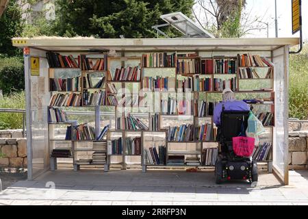 220422 -- JÉRUSALEM, le 22 avril 2022 -- Un homme lit un livre dans une bibliothèque de rue à Jérusalem avant la Journée mondiale du livre, le 22 avril 2022. Le 23 avril marque la Journée mondiale du livre. MIDEAST-JERUSALEM-WORLD BOOK DAY-STREET LIBRARY WANGXZHUOLUN PUBLICATIONXNOTXINXCHN Banque D'Images