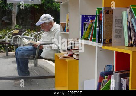 220422 -- JÉRUSALEM, le 22 avril 2022 -- Un homme lit un livre dans une bibliothèque de rue à Jérusalem avant la Journée mondiale du livre, le 22 avril 2022. Le 23 avril marque la Journée mondiale du livre. MIDEAST-JERUSALEM-WORLD BOOK DAY-STREET LIBRARY WANGXZHUOLUN PUBLICATIONXNOTXINXCHN Banque D'Images