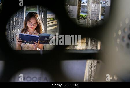 220423 -- MANILLE, le 23 avril 2022 -- Une femme lit un livre à l'arrêt du livre sur une place lors de la Journée mondiale du livre à Manille, aux Philippines, le 23 avril 2022. Le Book Stop à Manille est une bibliothèque pop-up avec le slogan donner un livre, obtenir un livre pour encourager les gens à lire et promouvoir le partage des idées par la redistribution des livres. PHILIPPINES-MANILA-WORLD BOOK DAY-POP-UP LIBRARY ROUELLEXUMALI PUBLICATIONXNOTXINXCHN Banque D'Images