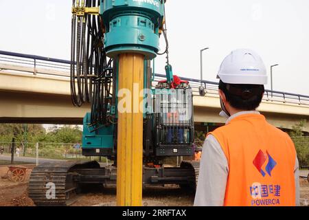 220425 -- TEL AVIV, le 25 avril 2022 -- des constructeurs chinois travaillent sur le chantier de construction de la ligne verte de train léger de tel Aviv dans le nord de tel Aviv, Israël, le 24 avril 2022. La construction d'un tronçon de la ligne verte de tramway de tel Aviv a débuté dimanche, comprenant la station de Reading et un pont au-dessus du fleuve Yarkon. Le projet, entrepris par Power Construction Corporation of China PCCC, devrait être achevé en 2024 avec un pont de 700 mètres de long et de 13 mètres de large, ainsi qu’une station couvrant environ 2 400 mètres carrés. ISRAËL-TEL AVIV-CONSTRUCTION DE RAILS LÉGERS-PUBLICATION WANGXZHUOLUN Banque D'Images