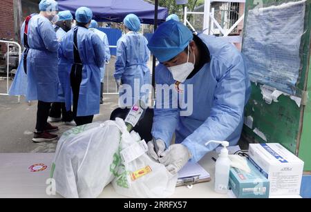 220428 -- BEIJING, le 28 avril 2022 -- des travailleurs communautaires ramassent des colis pour les résidents d'une communauté du district de Chaoyang à Beijing, capitale de la Chine, le 28 avril 2022. Lors de la dernière résurgence des infections COVID-19 à Pékin, des personnes de différents horizons se sont jointes à la lutte contre le coronavirus, travaillant contre la montre pour offrir un soutien chaleureux. CHINE-PÉKIN-COVID-19 CN LixXin PUBLICATIONxNOTxINxCHN Banque D'Images