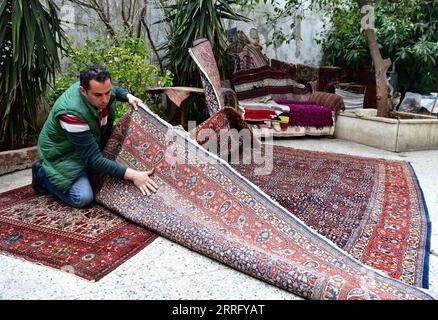 220429 -- ALEP SYRIE, 29 avril 2022 -- Omar Rawas, un tisserand de tapis, vérifie un tapis dans son atelier à Alep, en Syrie, le 8 mars 2022. Avant que la guerre n'éclate en Syrie en 2011, l'activité de réparation de tapis consistait principalement à réparer des tapis anciens et coûteux faits à la main, qui étaient considérés comme du patrimoine et des trésors en raison de leur valeur. Cependant, la situation a maintenant changé car les gens peuvent difficilement se permettre de nouveaux tapis coûteux dans le contexte de la crise économique résultant des longues années de guerre et des sévères sanctions économiques imposées par les États-Unis à la Syrie. Photo de /Xinhua TO GO WITH Feature: Banque D'Images