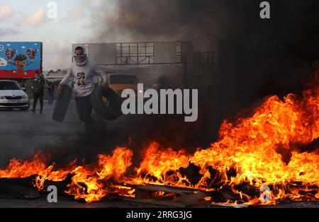 220505 -- NAPLOUSE, le 5 mai 2022 -- Un manifestant palestinien brûle des pneus lors d'affrontements avec des soldats israéliens à la suite d'une manifestation de soutien aux Palestiniens à Jérusalem au point de contrôle de Hawara dans la ville de Naplouse en Cisjordanie, le 5 mai 2022. Photo de /Xinhua MIDEAST-NAPLOUSE-CLASHS AymanxNobani PUBLICATIONxNOTxINxCHN Banque D'Images
