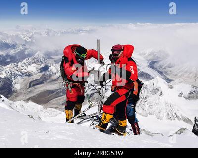 220509 -- CAMP DE BASE DU MONT QOMOLANGMA, le 9 mai 2022 -- Dechen Ngodrup L installe une station de surveillance météorologique automatique sur le mont Qomolangma le 4 mai 2022. Mercredi, 13 membres d'une équipe d'expédition chinoise ont atteint le sommet du plus haut sommet du monde à une hauteur de 8 848,86 mètres. L'escouade a établi une station de surveillance météorologique automatique à une altitude de 8 830 mètres, la plus haute du genre au monde. Ils ont également mesuré l'épaisseur de la glace et de la neige à l'aide d'un radar de haute précision et ont recueilli des échantillons pour d'autres recherches au sommet. Dechen Ngodrup, chef de l'équipe qui h Banque D'Images