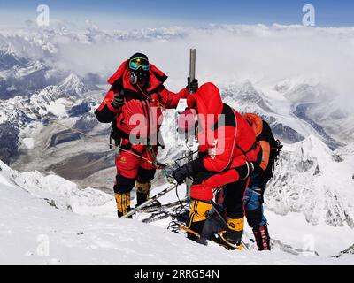 220509 -- CAMP DE BASE DU MONT QOMOLANGMA, le 9 mai 2022 -- Dechen Ngodrup L installe une station de surveillance météorologique automatique sur le mont Qomolangma le 4 mai 2022. Mercredi, 13 membres d'une équipe d'expédition chinoise ont atteint le sommet du plus haut sommet du monde à une hauteur de 8 848,86 mètres. L'escouade a établi une station de surveillance météorologique automatique à une altitude de 8 830 mètres, la plus haute du genre au monde. Ils ont également mesuré l'épaisseur de la glace et de la neige à l'aide d'un radar de haute précision et ont recueilli des échantillons pour d'autres recherches au sommet. Dechen Ngodrup, chef de l'équipe qui h Banque D'Images