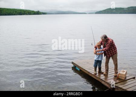 Homme senior montrant à son petit-fils comment pêcher hors quai au lac Kezar Banque D'Images