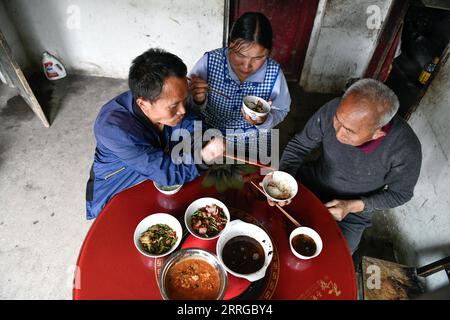 220516 -- ZUNYI, le 16 mai 2022 -- Zhao Youliang L va chercher de la nourriture pour son père au déjeuner dans le canton de Zhongguan, comté de Zheng an, province du Guizhou au sud-ouest de la Chine, le 12 mai 2022. Vivant au cœur des montagnes de Zunyi dans la province du Guizhou, Zhao Youliang et Jian Qin sont un couple handicapé. Zhao, âgé de 50 ans, a perdu ses mains à cause d'une amputation à un jeune âge, et Jian, âgée de 43 ans, a perdu la vue à cause du retard dans le traitement d'une maladie dans son enfance. Dans la vie quotidienne, Zhao aide sa femme à voir avec ses yeux, tandis que Jian aide son mari avec ses mains. Le couple l'a été Banque D'Images