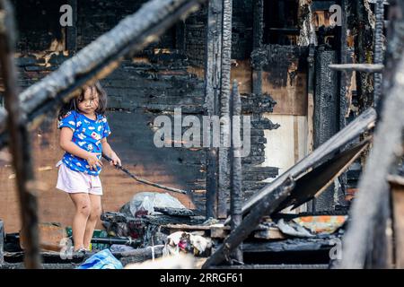 220520 -- MANILLE, le 20 mai 2022 -- Une fille est vue à l'intérieur d'une maison carbonisée après un incendie dans un bidonville à Manille, aux Philippines, le 20 mai 2022. Jeudi soir, un incendie a traversé un bidonville près du port principal de la capitale philippine, menaçant de nombreux navires amarrés dans la région, a déclaré le PCG des garde-côtes philippins. PHILIPPINES-MANILLE-FEU-APRES RouellexUmali PUBLICATIONxNOTxINxCHN Banque D'Images