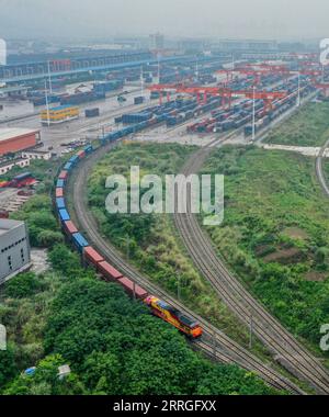 220521 -- CHONGQING, le 21 mai 2022 -- une photo aérienne prise le 21 mai 2022 montre un train de marchandises Chine-Laos partant d'une gare dans la municipalité de Chongqing du sud-ouest de la Chine. Un train de marchandises transportant des aliments locaux et des machines agricoles est parti samedi d'une gare dans la municipalité de Chongqing du sud-ouest de la Chine pour Vientiane, capitale du Laos, marquant le lancement du premier train de marchandises Chine-Laos qui bénéficie d'un canal d'entrée et d'exportation rapide favorable. Le canal d'entrée et d'exportation rapide économise 24 heures dans le processus de dédouanement de cargaison, ce qui aide à raccourcir le temps de trajet pour le transport de fret. MENTON Banque D'Images