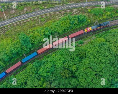 220521 -- CHONGQING, le 21 mai 2022 -- une photo aérienne prise le 21 mai 2022 montre un train de marchandises Chine-Laos partant d'une gare dans la municipalité de Chongqing du sud-ouest de la Chine. Un train de marchandises transportant des aliments locaux et des machines agricoles est parti samedi d'une gare dans la municipalité de Chongqing du sud-ouest de la Chine pour Vientiane, capitale du Laos, marquant le lancement du premier train de marchandises Chine-Laos qui bénéficie d'un canal d'entrée et d'exportation rapide favorable. Le canal d'entrée et d'exportation rapide économise 24 heures dans le processus de dédouanement de cargaison, ce qui aide à raccourcir le temps de trajet pour le transport de fret. MENTON Banque D'Images