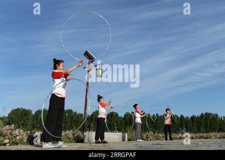 220528 -- WUQIAO, le 28 mai 2022 -- des étudiants d'un centre d'art pratiquent des acrobaties dans un parc le long du Grand Canal dans le comté de Wuqiao de Cangzhou, province du Hebei, dans le nord de la Chine, le 25 mai 2022. Considéré comme le berceau des acrobaties chinoises, Wuqiao est un comté que traverse le Grand Canal, vaste voie navigable reliant les parties nord et sud de la Chine. Bénéficiant de la ceinture culturelle construite le long du canal, le comté a favorisé le développement intégré du tourisme et de l'agriculture basé sur ses ressources acrobatiques uniques. CHINE-HEBEI-WUQIAO-GRAND CANAL CN LUOXXUEFENG PUBLICATIONXNOTXINXCHN Banque D'Images