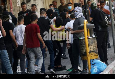 220529 -- HÉBRON, le 29 mai 2022 -- des manifestants palestiniens portent un homme blessé lors d'affrontements avec des soldats israéliens à la suite d'une manifestation contre la marche du drapeau dans la ville d'Hébron en Cisjordanie, le 29 mai 2022. La marche controversée du drapeau organisée par des groupes israéliens d’extrême droite devrait avoir lieu dimanche pour marquer la Journée de Jérusalem, qui commémore l’unification de la ville après l’annexion par Israël de Jérusalem-est en 1967. Son itinéraire devrait passer par la porte de Damas et le quartier islamique dans la vieille ville. Photo de /Xinhua MIDEAST-HEBRON-PROTEST MamounxWazwaz PUBLICATIONxNOTxINxCHN Banque D'Images