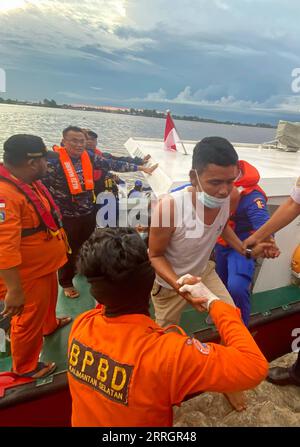 220529 -- BANJARMASIN, le 29 mai 2022 -- une photo de téléphone portable prise le 29 mai 2022 montre des sauveteurs détenant un survivant au port de Trisakti à Banjarmasin, dans le sud du Kalimantan, en Indonésie. Les sauveteurs ont déployé un hélicoptère et plusieurs navires avec plus de 100 personnes dans une opération de recherche et de sauvetage pour 25 personnes disparues après qu'un navire a coulé dans l'eau au large de la province de Sulawesi du Sud en Indonésie, a déclaré dimanche un sauveteur. Photo de /Xinhua INDONESIA-SOUTH KALIMANTAN-BANJARMASIN-SOUTH SULAWESI-NAVIRE-CHAVIREMENT-SAUVETAGE BahaudinxQusairi PUBLICATIONxNOTxINxCHN Banque D'Images