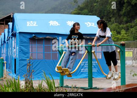 220602 -- ya AN, le 2 juin 2022 -- deux filles font de l'exercice dans un refuge temporaire dans le village de Dahe, dans le comté de Lushan, dans le sud-ouest de la Chine, dans la province du Sichuan, le 2 juin 2022. Quatre personnes ont été confirmées mortes et 41 autres blessées après un tremblement de terre de magnitude 6,1 qui a secoué la ville de ya an, dans la province du Sichuan, dans le sud-ouest de la Chine, mercredi après-midi, selon le siège des secours anti-séisme de la ville, jeudi. Les opérations de sauvetage sont menées de manière ordonnée. CHINE-SICHUAN-YA AN-TREMBLEMENT DE TERRE-ÉCOLE-SAUVETAGE CN SHENXBOHAN PUBLICATIONXNOTXINXCHN Banque D'Images