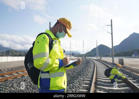 220603 -- VIENTIANE, le 3 juin 2022 -- Un employé du centre de gestion des opérations de Luang Prabang de la Laos-China Railway Co., Ltd. Enregistre des données pendant qu'il effectue des travaux de maintenance d'une ligne de chemin de fer dans la province de Luang Prabang, Laos, le 30 mai 2022. Le chemin de fer Chine-Laos, six mois après le début de son exploitation, a livré plus de 4 millions de tonnes de fret jeudi, a déclaré l opérateur ferroviaire chinois. En tant que projet phare dans le cadre de l'Initiative ceinture et route, le chemin de fer de 1 035 km relie Kunming de la Chine à la capitale laotienne Vientiane. /Document via Xinhua CHINA-LAOS RAILWAY-OPERATION-SEMESTRIEL LCRC Banque D'Images