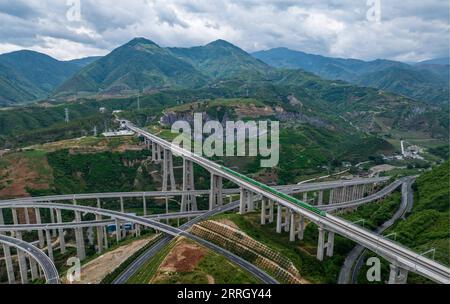 220603 -- KUNMING, le 3 juin 2022 -- une photo aérienne montre un train à grande vitesse Fuxing traversant le grand pont Nanxihe sur le chemin de fer Chine-Laos dans la province du Yunnan au sud-ouest de la Chine, le 2 juin 2022. Le chemin de fer Chine-Laos, six mois après le début de son exploitation, a livré plus de 4 millions de tonnes de fret jeudi, a déclaré l opérateur ferroviaire chinois. Selon China State Railway Group Co., Ltd., le volume de transport de marchandises transfrontalières a atteint 647 000 tonnes au cours de la période La ligne de train a également traité plus de 3,2 millions de voyages de passagers, a déclaré l'opérateur. Depuis le 2021 décembre 21 Chinois Banque D'Images