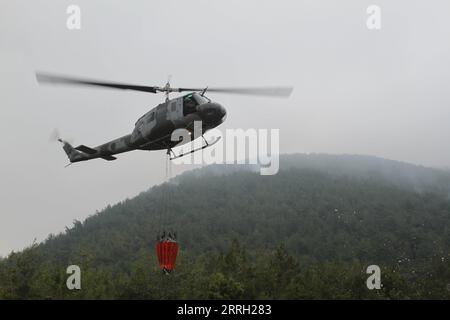 220609 -- DANNIYEH, le 9 juin 2022 -- Un hélicoptère de l'armée libanaise transporte de l'eau pour éteindre un incendie dans la forêt de pins de Danniyeh, au Liban, le 8 juin 2022. Photo de /Xinhua LEBANON-DANNIYEH-FEU DE FORÊT KhaledxHabashiti PUBLICATIONxNOTxINxCHN Banque D'Images