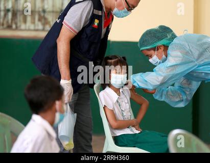 220610 -- YANGON, le 10 juin 2022 -- Un étudiant reçoit une dose de vaccin contre le COVID-19 dans une école de Yangon, Myanmar, le 10 juin 2022. Le Myanmar administre des vaccins contre le COVID-19 aux enfants âgés de cinq à 12 ans dans les écoles d’éducation de base à travers le pays depuis juin 2, a rapporté vendredi la chaîne de télévision publique MRTV. MYANMAR-YANGON-COVID-19-VACCIN-ENFANTS UxAung PUBLICATIONxNOTxINxCHN Banque D'Images