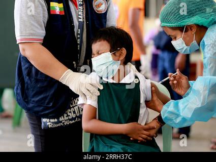 220610 -- YANGON, le 10 juin 2022 -- Un étudiant reçoit une dose de vaccin contre le COVID-19 dans une école de Yangon, Myanmar, le 10 juin 2022. Le Myanmar administre des vaccins contre le COVID-19 aux enfants âgés de cinq à 12 ans dans les écoles d’éducation de base à travers le pays depuis juin 2, a rapporté vendredi la chaîne de télévision publique MRTV. MYANMAR-YANGON-COVID-19-VACCIN-ENFANTS UxAung PUBLICATIONxNOTxINxCHN Banque D'Images