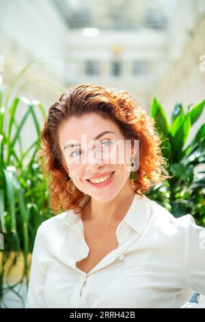 Portrait d'une belle femme à la mode aux cheveux rouges dans un café. Banque D'Images