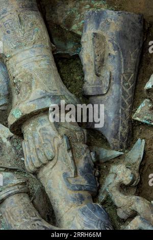 220616 -- GUANGHAN, le 16 juin 2022 -- la photo prise le 1 juin 2022 montre des parties dispersées d'une sculpture en bronze récemment mise au jour dans la fosse sacrificielle n° 8 sur le site des ruines de Sanxingdui dans la province du Sichuan du sud-ouest de la Chine. Une sculpture en bronze récemment déterrée sur le célèbre site des ruines de Sanxingdui a été jumelée avec succès avec une autre partie de bronze après avoir été mise à part il y a environ 3 000 ans, a confirmé jeudi l'équipe archéologique. La sculpture sophistiquée en bronze représente une figure d'une tête humaine et d'un corps de serpent, avec des yeux saillants, des défenses et des cornes. Au-dessus de la tête se trouve une trompette cinabre Banque D'Images