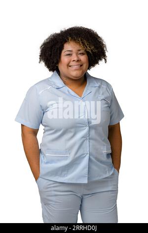Portrait vertical de la taille vers le haut de jeune femme vénézuélienne afro-latino en uniforme bleu, cheveux afro, debout souriant et regardant la caméra heureuse. Fond blanc Banque D'Images