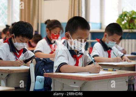 220627 -- BEIJING, le 27 juin 2022 -- des étudiants suivent un cours de chinois sur le campus de Pinggu de l'école primaire expérimentale n° 2 de Beijing, capitale de la Chine, le 27 juin 2022. Les élèves du primaire et du collège de Pékin sont retournés sur le campus lundi après plus de 50 jours d éducation à distance en raison d une résurgence locale du COVID-19. Les élèves des deux premières années du premier cycle du secondaire et du deuxième cycle du secondaire, ou des 7e, 8e, 10e et 11e années, ainsi que ceux des écoles primaires, ont repris les cours en personne. L ' éducation des élèves des 9e et 12e années s ' est achevée plus tôt. CHINE-PÉKIN-L'ÉCOLE ROUVRE CN RENXCHAO Banque D'Images