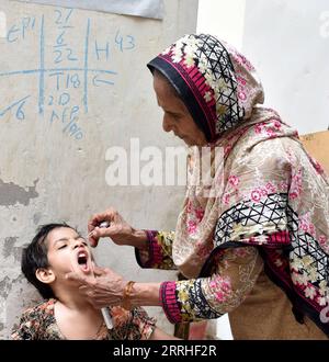 220628 -- LAHORE PAKISTAN, le 28 juin 2022 -- Un agent de santé administre un vaccin contre la poliomyélite à un enfant lors d'une campagne de vaccination à Lahore, au Pakistan, le 27 juin 2022. Photo de /Xinhua PAKISTAN-LAHORE-POLIO-VACCINATION Sajjad PUBLICATIONxNOTxINxCHN Banque D'Images