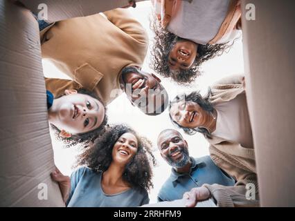 Famille, boîte ouverte et sourire d'en bas en portrait, cercle ou excité pour cadeau, cadeau ou déménagement ensemble dans la maison. Heureux, groupe ou parents donnant Banque D'Images