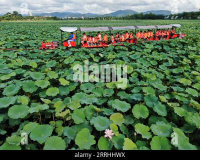 220702 -- JINGHONG, 2 juillet 2022 -- une photo aérienne prise le 2 juillet 2022 montre des visiteurs qui prennent un mini train touristique pour profiter des fleurs de lotus au lac Longde dans la ville de Jinghong de la préfecture autonome de Xishuangbanna Dai, province du Yunnan dans le sud-ouest de la Chine. Photo de /Xinhua CHINA-YUNNAN-JINGHONG-LOTUS FLOWER-SIGHTSEEING CN LixYunsheng PUBLICATIONxNOTxINxCHN Banque D'Images