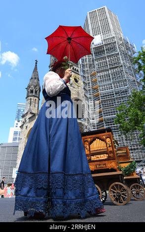 220702 -- BERLIN, le 2 juillet 2022 -- Une femme assiste à un défilé d'un festival international d'orgue à canon à Berlin, en Allemagne, le 2 juillet 2022. Un total de plus de 100 joueurs d'orgue à canon divertissent les visiteurs avec leurs instruments ici du vendredi au dimanche. ALLEMAGNE-BERLIN-BARREL ORGAN FESTIVAL RenxPengfei PUBLICATIONxNOTxINxCHN Banque D'Images