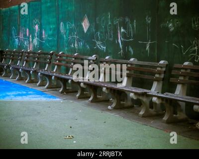 Bancs dans une aire de jeux avec un graffiti vandalisé la clôture de construction derrière elle à Chelsea à New York le jeudi 24 août 2023. (© Richard B. Levine) Banque D'Images