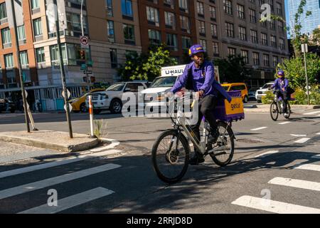 Les travailleurs du service de livraison d’épicerie super rapide Getir sur leurs vélos électriques à Chelsea à New York le jeudi 31 août 2023. Getir a été créé en Turquie en 2015 et s'est étendu en Europe à l'origine. (© Richard B. Levine) Banque D'Images