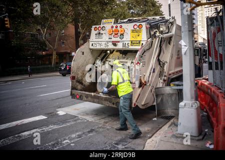 Un travailleur du Département de l'assainissement de la ville de New York charge son camion dans le quartier de Chelsea à New York le dimanche 3 septembre 2023. (© Richard B. Levine) Banque D'Images