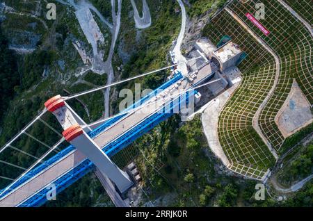 220727 -- SHANGRI-LA, 27 juillet 2022 -- une photo aérienne prise le 26 juillet 2022 montre le grand pont de la rivière Jinsha relié à l'entrée du tunnel de la montagne Haba le long de la voie ferrée Lijiang-Shangri-la dans la province du Yunnan au sud-ouest de la Chine. Avec une vitesse prévue de 120 kilomètres à l'heure, le chemin de fer Lijiang-Shangri-la, d'une longueur de 140 kilomètres, devrait raccourcir le temps de trajet entre Lijiang et Shangri-la après son exploitation. CHINA-YUNNAN-SHANGRI-LA-RAILWAY-CONSTRUCTION CN CHENXXINBO PUBLICATIONXNOTXINXCHN Banque D'Images