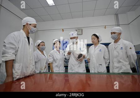 220727 -- CHENGDU, 27 juillet 2022 -- Yang Yinyu 3rd R discute avec des membres de l'équipe lors d'un atelier de Sichuan Aerospace Chuannan initiant explosive Technology Limited à Luzhou, dans la province du Sichuan du sud-ouest de la Chine, le 14 juillet 2022. Yang Yinyu est un technicien de classe spéciale et un ingénieur principal chez Sichuan Aerospace Chuannan à l'origine de explosive Technology Limited. Le travail de Yang et de son équipe comprend la production de dispositifs explosifs initiateurs de différents types. Ces dispositifs jouent un rôle crucial dans le processus allant de l'allumage de la fusée et de la séparation du booster à la décharge du carénage et à la séparation du capsu Banque D'Images