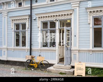 Scène de rue Tallinn, vélo jaune devant la façade en bois, Estonie Banque D'Images