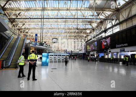 220821 -- LONDRES, le 21 août 2022 -- des membres du personnel se tiennent à Waterloo Station, à Londres, en Grande-Bretagne, le 20 août 2022. Cet été, alors que de nombreux Britanniques ont opté pour une escapade et que les hubs de transport à travers le Royaume-Uni étaient déjà sous pression, une autre série de grèves a plongé les transports publics dans le chaos cette semaine. Plus de 50 000 travailleurs des réseaux ferroviaires, de métro et de bus ont fait grève pour des raisons de salaire et de conditions de travail de jeudi jusque dans le week-end. Il est conseillé aux passagers de voyager uniquement en train si nécessaire. POUR ALLER AVEC la fonctionnalité : les plans de voyage ont été perturbés au Royaume-Uni car les grèves amènent des transp Banque D'Images