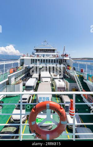 Croatie, baie de Kvarner, côte Adriatique, ferry de Lopar (île de Rab) à Valbiska (île de Krk), vue depuis le ferry avec les voitures garées et les passagers sur le pont Banque D'Images